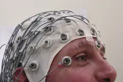 Човек с шапка с електроди за записване на електроенцефалограма